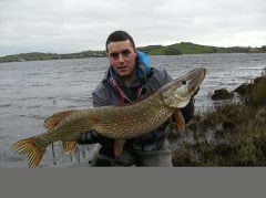 Boatman Justin Bird holds the 26 lb. pike for captor Jim 'Red' McKeever and is the Catch of the Week.