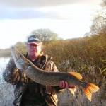 Ian at the water edge with his 12lb Pike