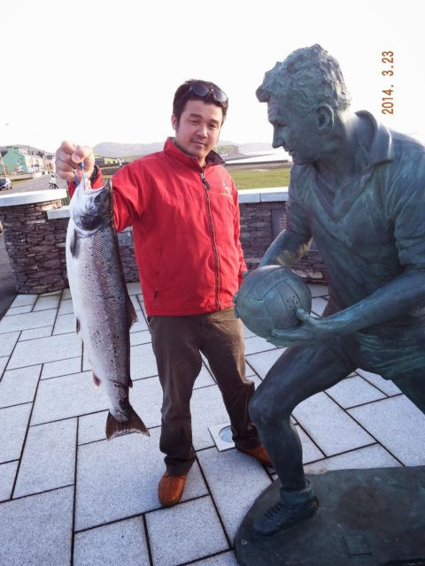 Tam with a lovely 14.5 lb. salmon from Lough Currane standing beside the statue of ledgendary Kerry footballer Mick O'Dywer in Waterville.