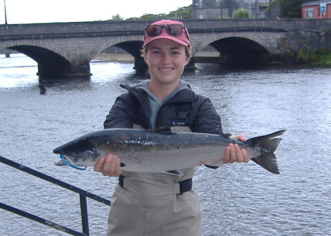 A smiling Phoebe Bean, US, with her 8 lbs. Cathedral Beat salmon