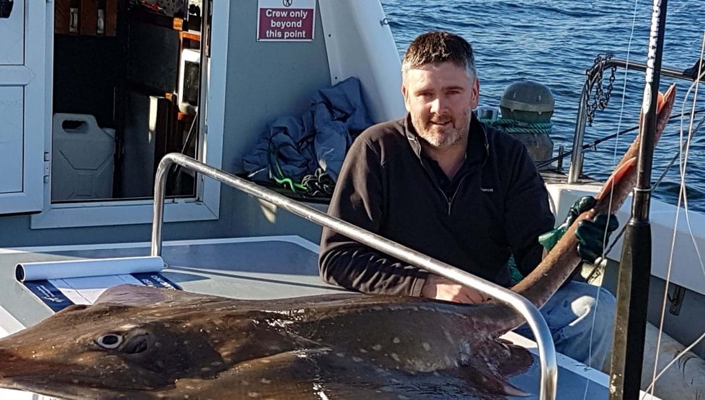 Angler poses with 210cm skate