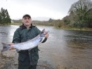 A dozen salmon from the Drowes in high water Eddie poses by the Drowes with his salmon