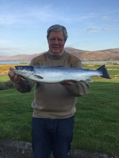 Andy with the first specimen Sea Trout of 2017 with te Premier Sea Trout Lake in Ireland in the background 