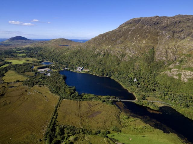 Aerial view of Castel Lough, Kylemore Abbey and mountains in background.
