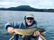 Storm Ellen fails to dampen spirits on Corrib Angler in boat on lake holding a very large trout.