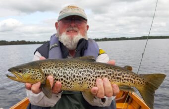 Up and down on Corrib – big fish for some anglers Angler in boat holding big trout