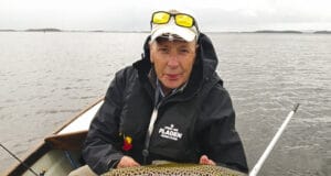 Angler in boat holding trout