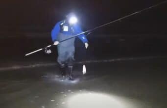 Angler in surf landing a fish