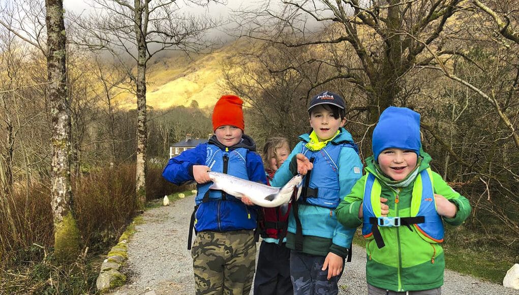 Four children holding a salmon