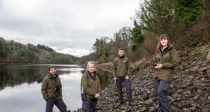 Four Fisheries Officers standing by a lake