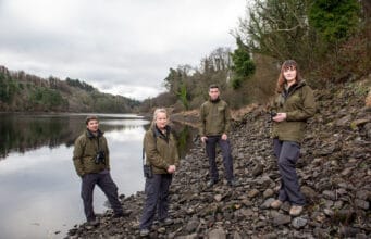 Four Fisheries Officers standing by a lake