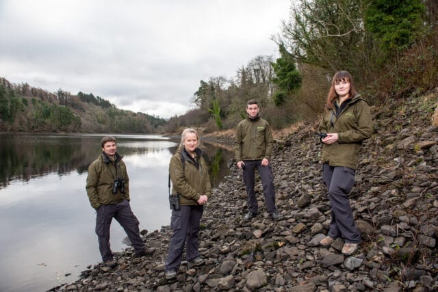 Four Fisheries Officers standing by a lake