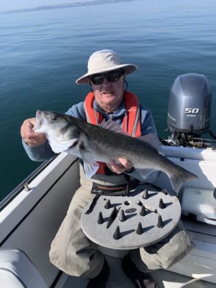 Richie poses with a bass on fly